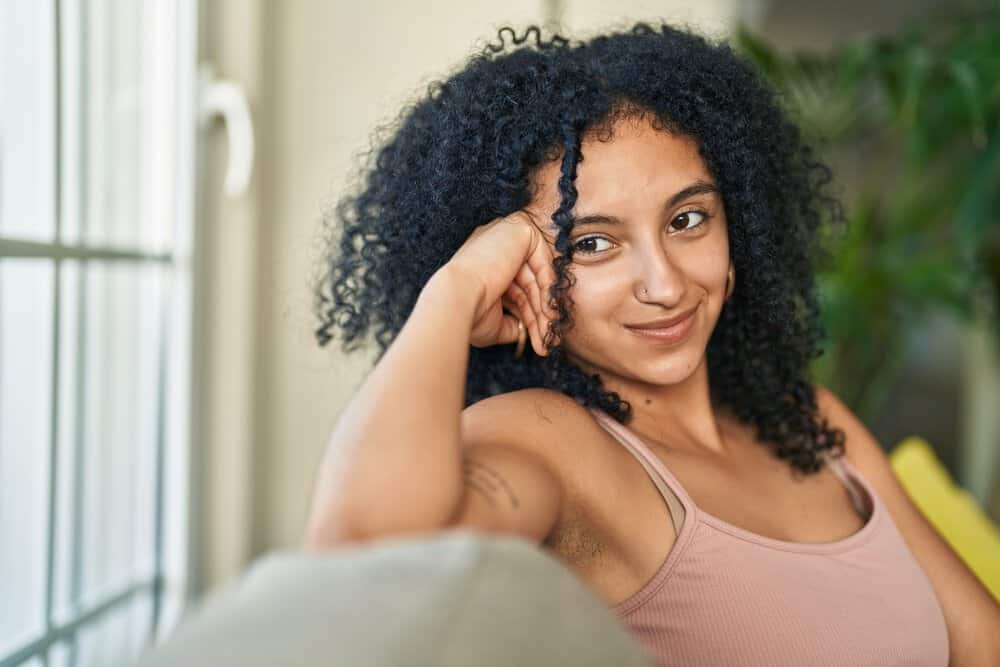 A young Hispanic female with long hair has a below average rate of slower hair growth due to the lack of essential nutrients from a high-quality diet.