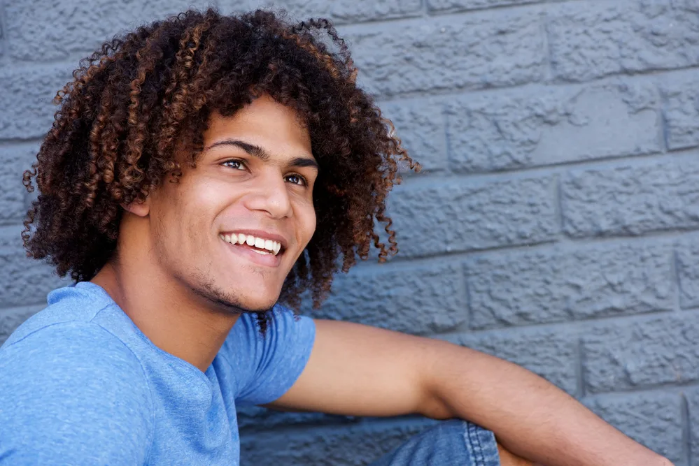 Long Hairstyles for Men: DIY Tutorials for Men's Long Hairstyles 13 Showcases a man with long, naturally wavy hair that cascades down in an ombre effect, reflecting the very epitome of men's long hairstyles.