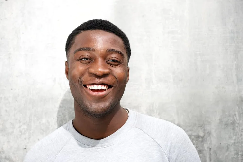 10 Different High Fade Haircuts for Black and White Guys 1 A black man wearing a modern high fade haircut on dark hair that requires very little effort each morning with hair on top of the head of this low maintenance hairstyle.