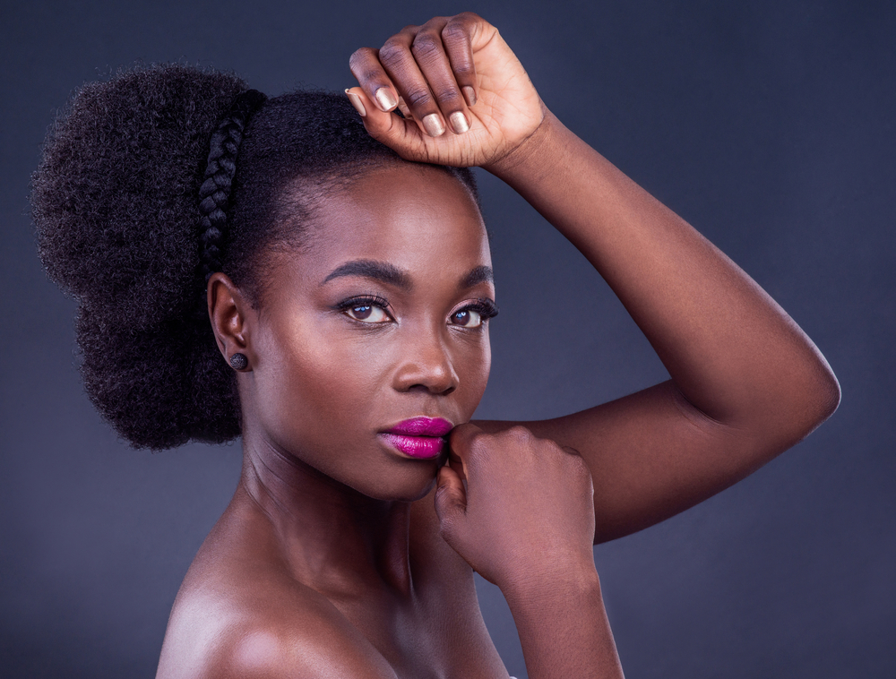 A captivating image of a black girl with type 4 natural hair highlights the importance of maintaining moisture with natural oils, like grapeseed oil and olive oil, to prevent dry hair.