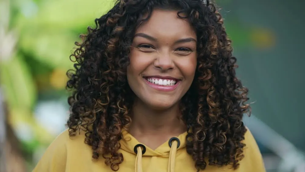 How to Dye Your Hair: Dye Hair at Home DIY Step-by-Step 1 A young Brazilian girl with color-treated hair has a slightly darker hair color than most ladies with brown hair and curls styled with natural oils and a wide-tooth comb.