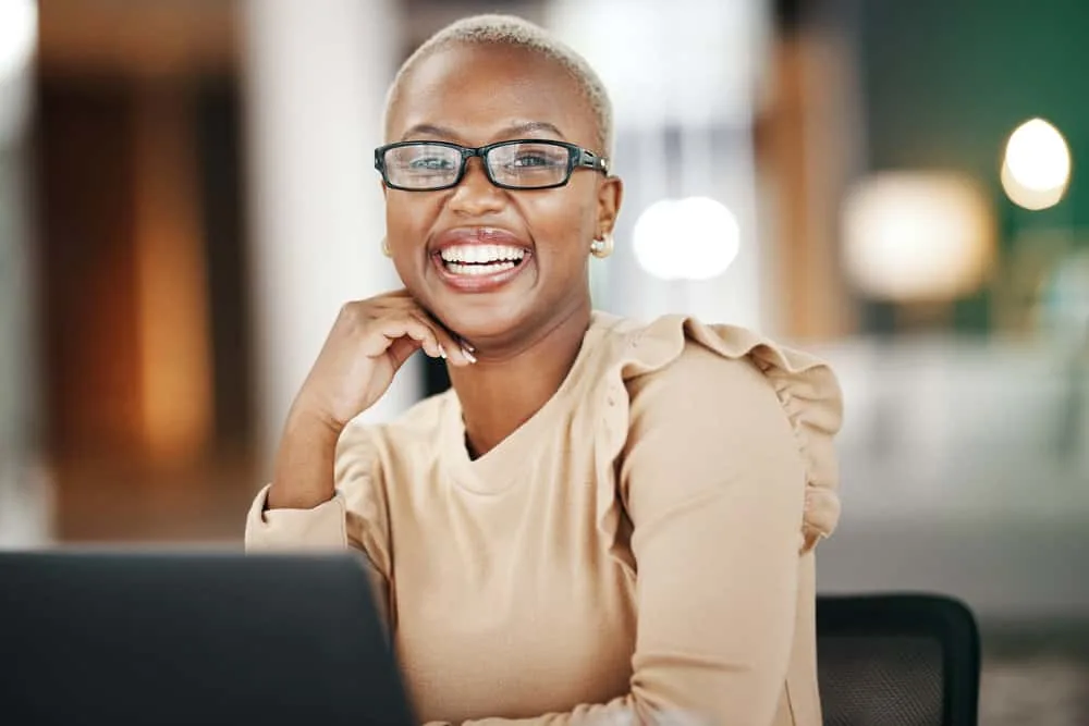 How to Go Back to Your Natural Hair Color After Dyeing Hair 1 A cute African American female with dark brown skin wearing colored hair dyed with a blonde semi-permanent hair color covering her black natural shade.
