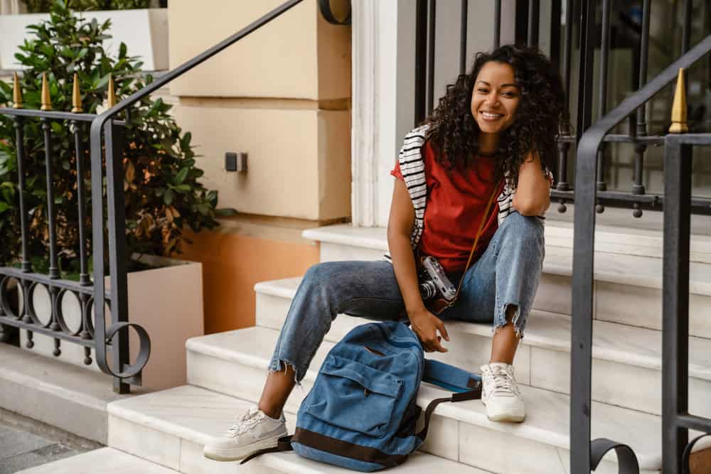 She embraces her natural curls, allowing her long curly hair to thrive by sleeping on silk pillowcases and using silk scrunchies or satin bonnets.