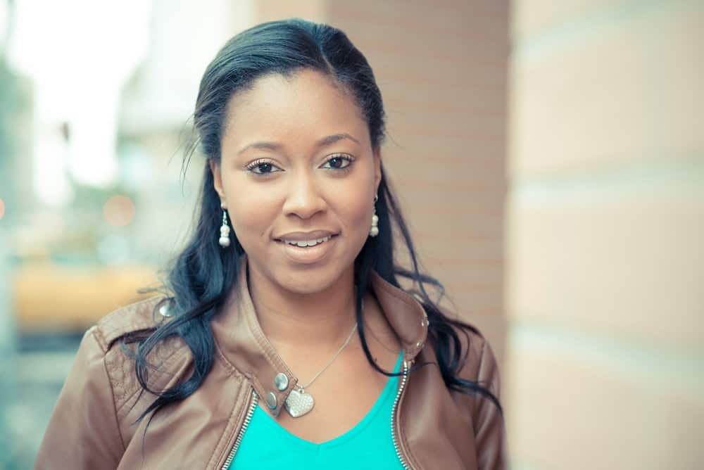 A beautiful African American woman with dark brown natural hair in a perfectly straight style after using a curly hair straightener on freshly washed hair.