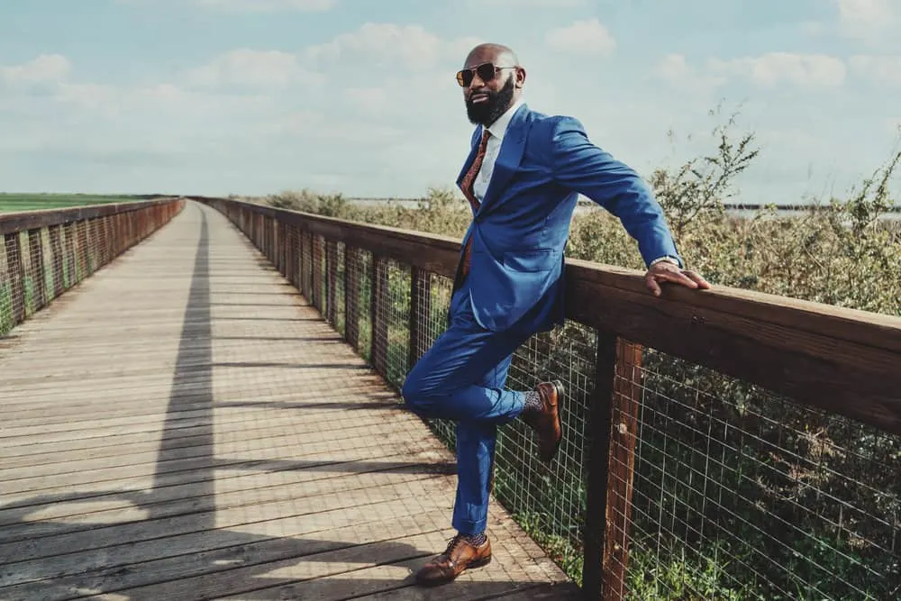 Sporting a tapered cut with thinner hair and a full beard, the gentleman's hairstyle highlights his face shape and draws attention to his striking features.