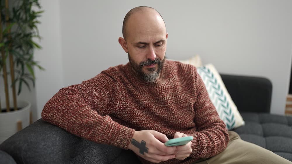 Despite his bald hair, the young man confidently rocks a shaved head, showcasing his individuality and embracing his balding crown.