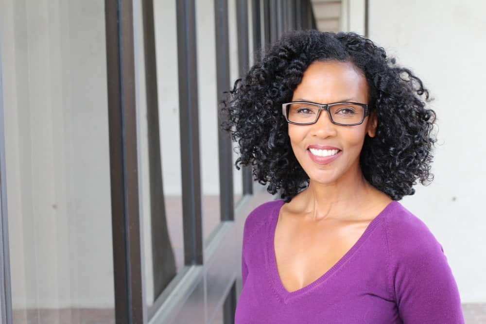 With her thin hair, an older woman rocks an attractive wavy bob that showcases her fine hair strands, adding sophistication to her look to her medium length hair.