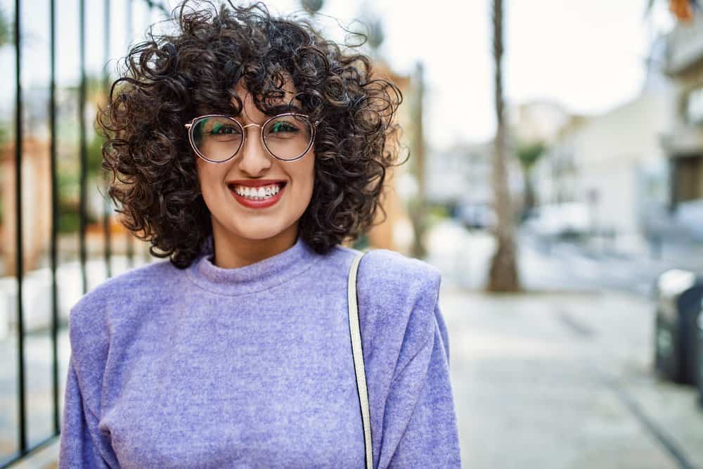 A young female's straight hair fibers are transformed into beautiful curls with a curling iron, highlighting the hair follicle shape and hook of the hair bulb.