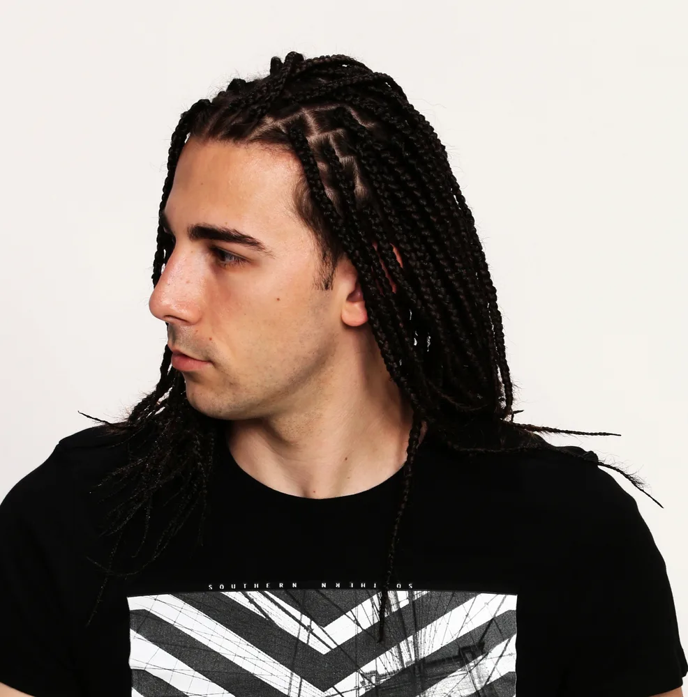The young Caucasian male confidently rocks a cool braid hairstyle, showcasing his appreciation for diverse braid styles and embracing the cultural trend.