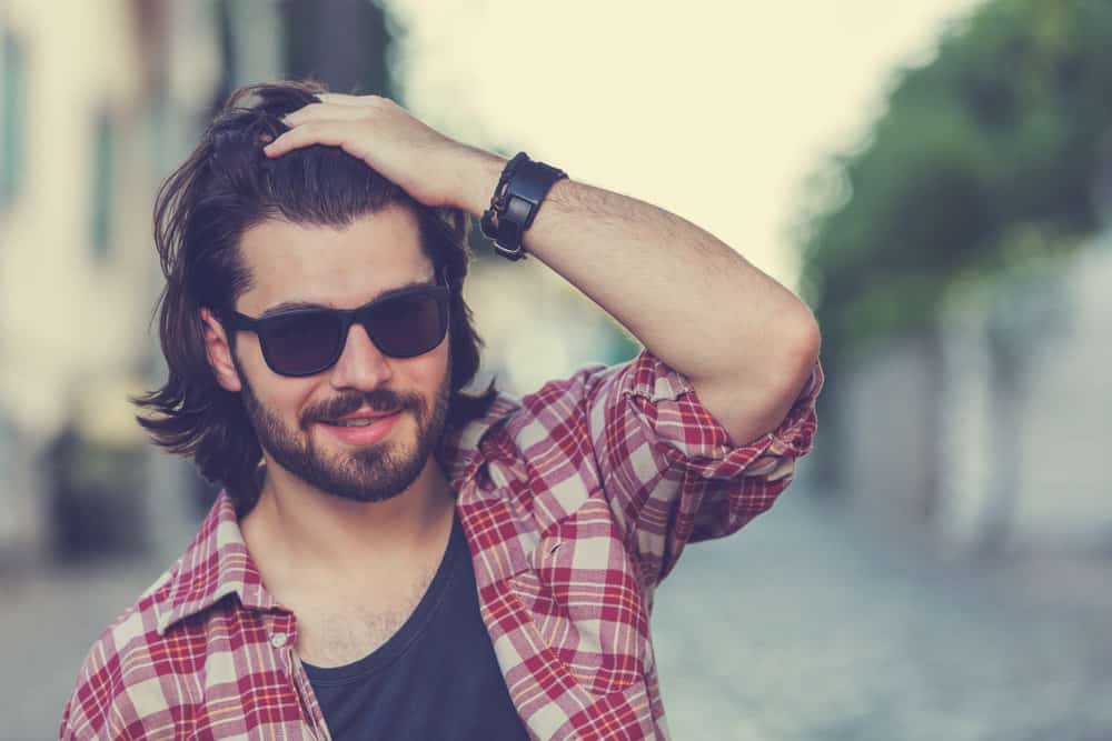 Sporting a sporty boy mullet, he embraces the short length in the front while the back showcases the natural curls in all their glory.