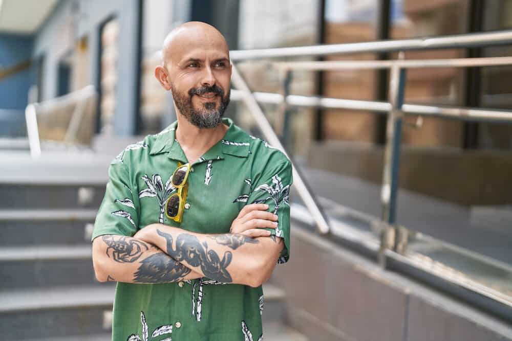 While his fine hair may be thinning, the young man rocks a shaved head, embracing his natural hair growth pattern and embracing his unique style.