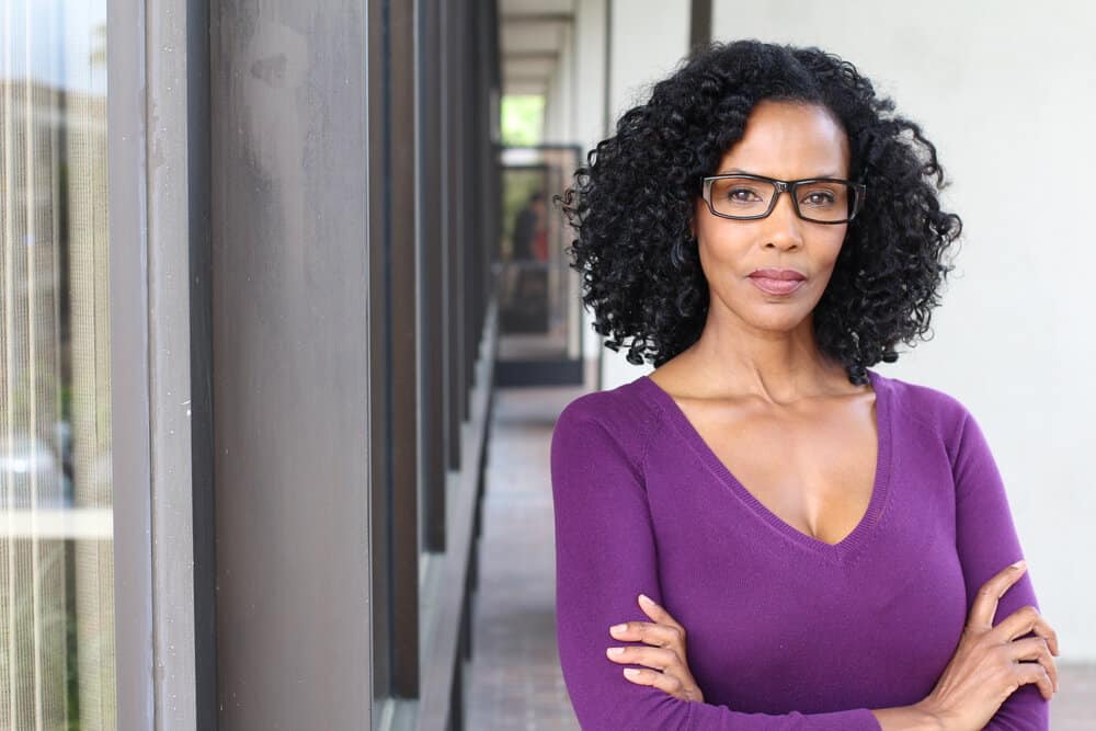 With a textured, layered haircut, her naturally wavy hair and salt and pepper strands create a youthful and vibrant appearance that works on curly or wavy hair types.