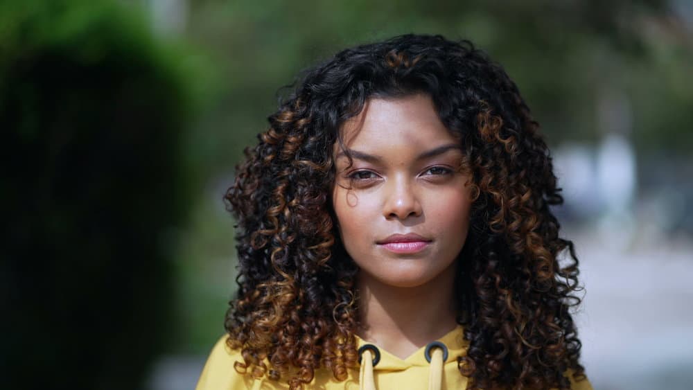 The young Brazilian girl in the image has a beautiful natural hair color with hints of blonde hair that she has enhanced using a hair color kit.