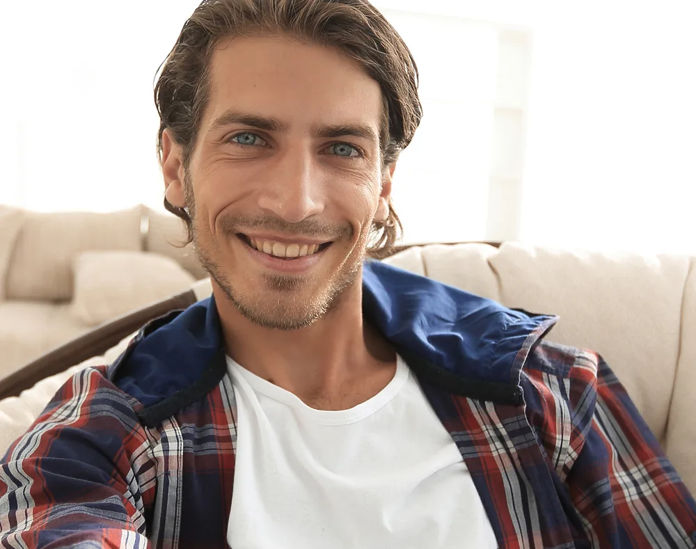 The Best Straight Hair Hairstyles: Men's Styles and Haircuts 1 A confident white guy with thin hair wearing one of our favorite straight hairstyles on her dark blonde hair strands that was styled with round brush for his type 2 hair texture.