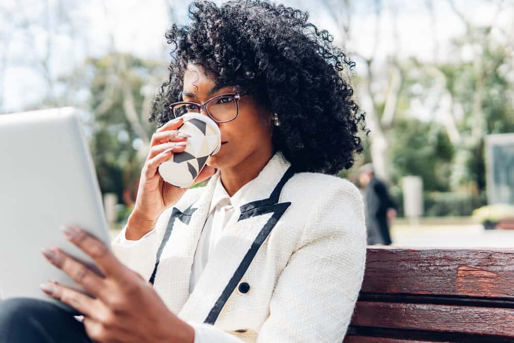 A black girl that allows her hair to air dry or uses a diffuser attachment on low heat to avoid heat damage and maintain the natural texture of her fine curls.