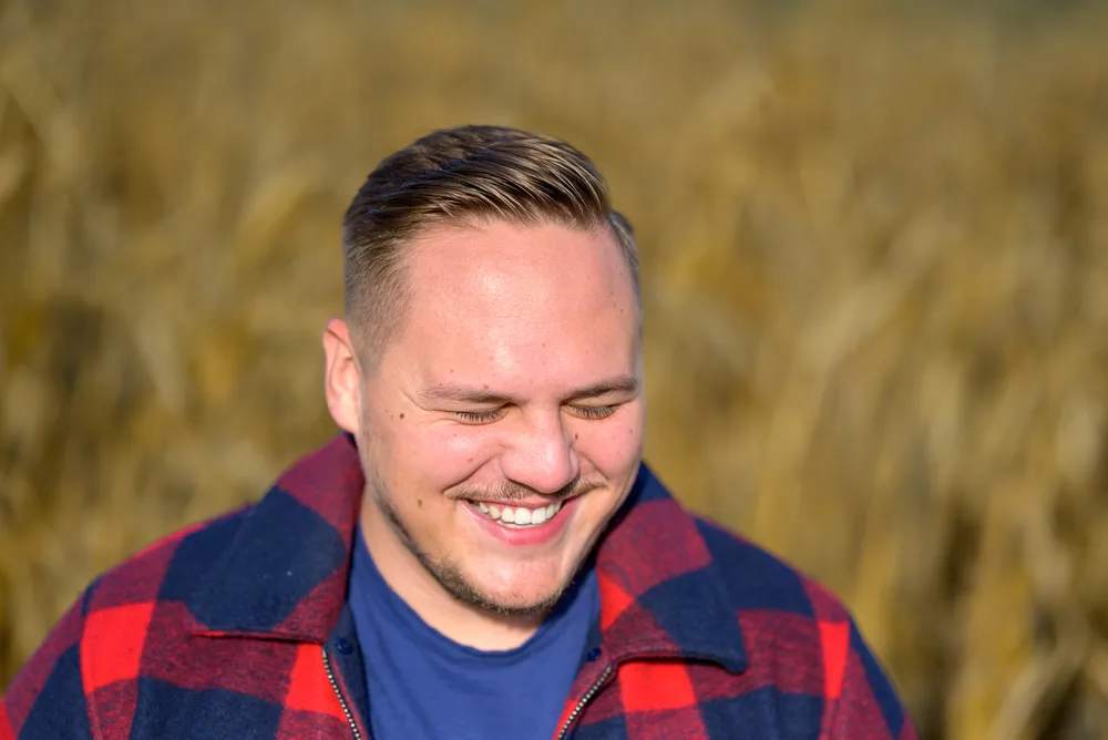 Best Haircuts for Men with Round Faces: Chubby Hairstyles for Guys 18 The young man's modern French crop accentuates his facial features, drawing attention to his smooth, medium-length hair and rounded jawline.