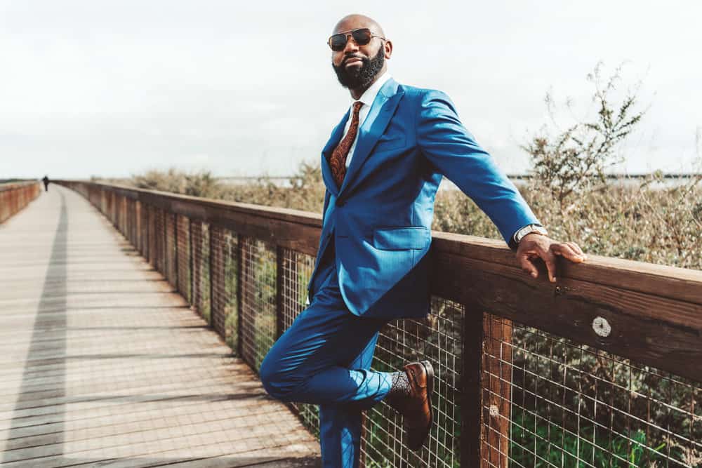 With his fine hair and well-groomed beard, the African man embraces a high skin fade, giving his look a stylish edge.