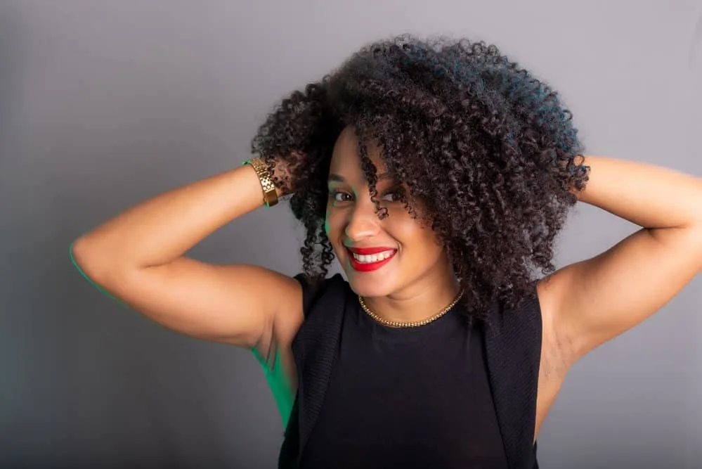 Embracing her wavy hair, she opts for a gentle drying process, using a diffuser attachment on low heat to protect her delicate hair cuticles.