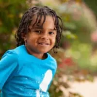 A cute African American toddler wearing little boy braids on his type 4 natural hair strands, a braided hairstyle that was created with zig-zag pattern.