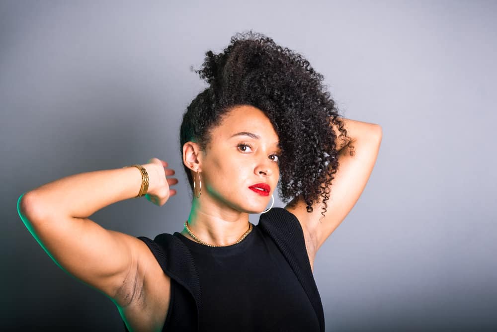 Using a wide-tooth comb, she carefully detangles her damp hair, ensuring that her curls remain intact and free from frizz.