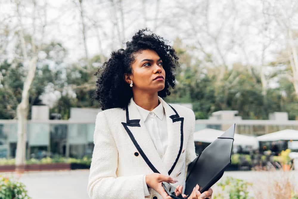 With her hair freshly washed and still wet, this black businesswoman is ready to style her wavy hair into defined curls using a curling iron.