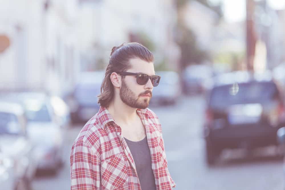 His shoulder-length hair, styled in a Mexican mullet, showcases the versatility of this haircut across different hair types.