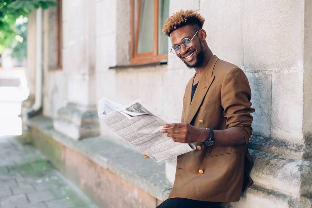 The contrast of the blonde tips against his natural dark brown hair creates a striking and dynamic, natural look.