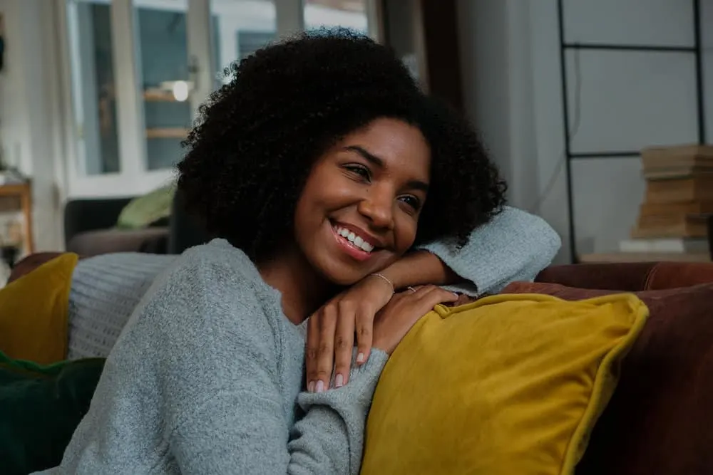 How to Cut Curly Hair: Cutting Hair at Home for Curly Girls 3 The pretty black woman showcases her voluminous curly hair with a stunning Deva cut, perfectly tailored to her 4A natural curl pattern.
