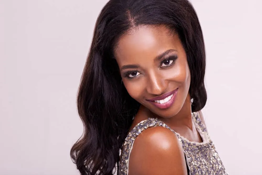 What Is a Silk Press? How Long Does a Silk Press Last? 1 A beautiful young woman with straight hair after getting a silk press and heat styling her naturally curly hair leaving it with a smooth and silky finish.
