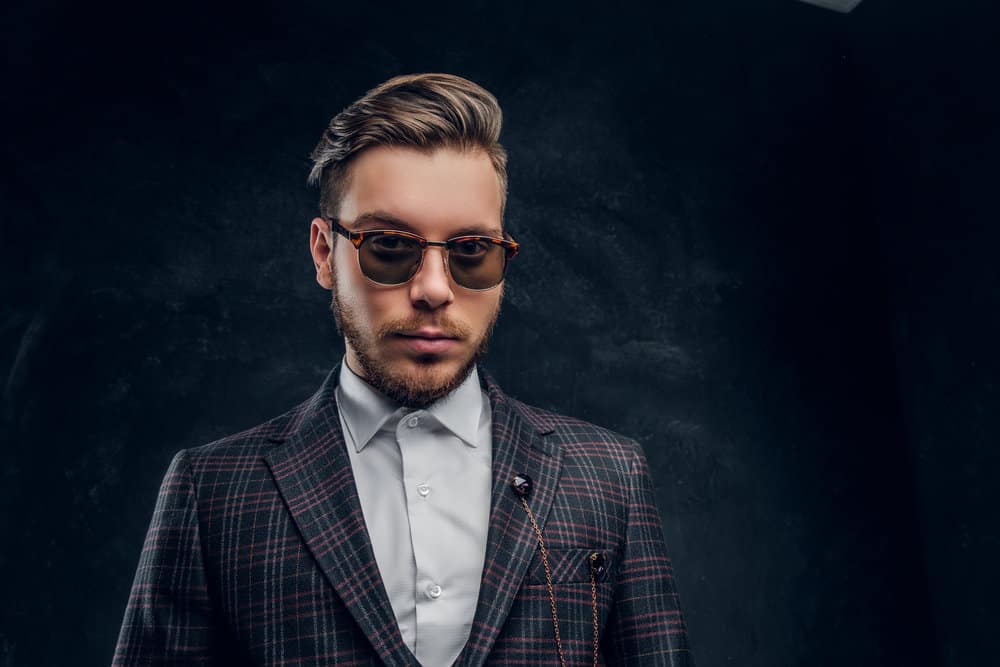 The young man confidently rocks a Michael Gray haircut, complete with a disconnected undercut and a meticulously maintained lumberjack beard.