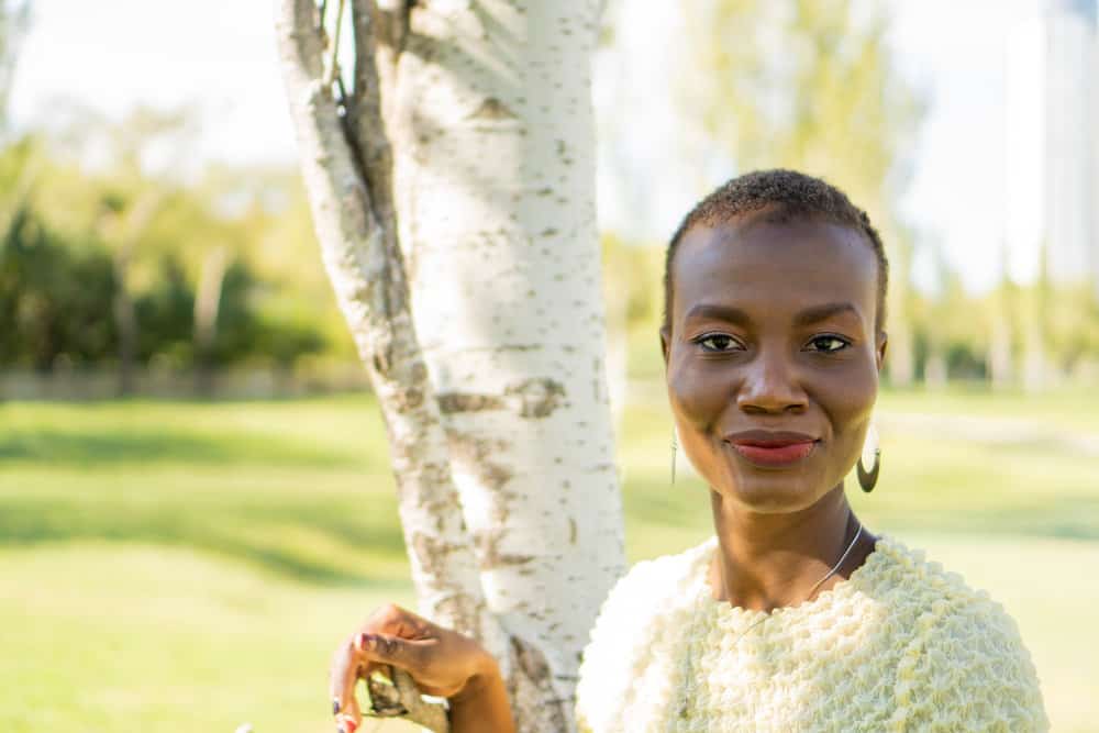 The young African American woman confidently rocks her natural curls in one of the most popular short haircuts for women, showcasing her fine hair beautifully.