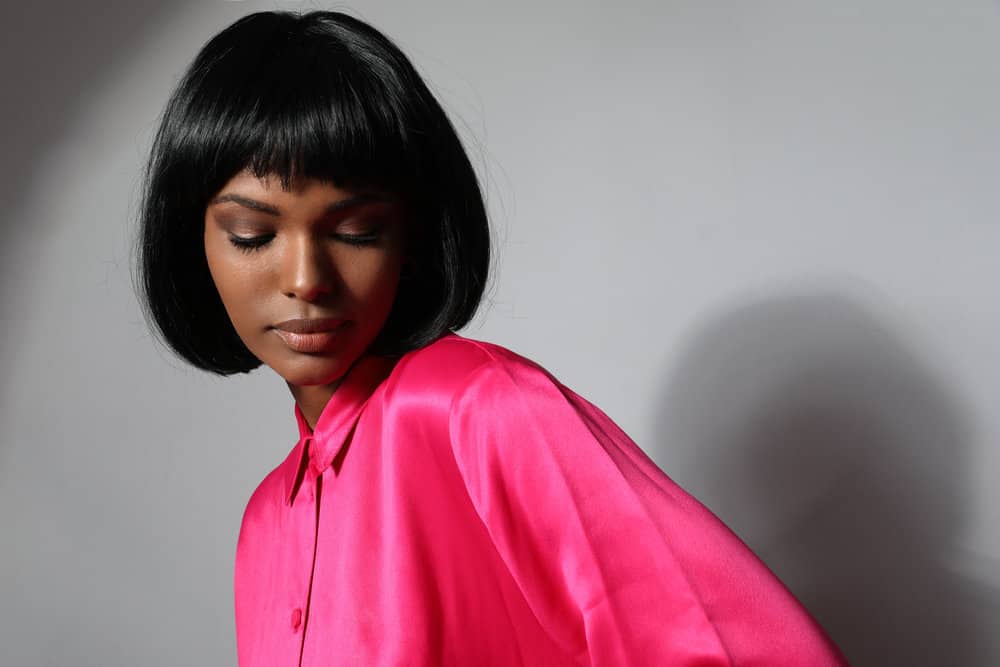 Her straight hair is expertly styled into a sleek and polished bob, accentuating her features and showcasing her style with blunt cutting techniques.