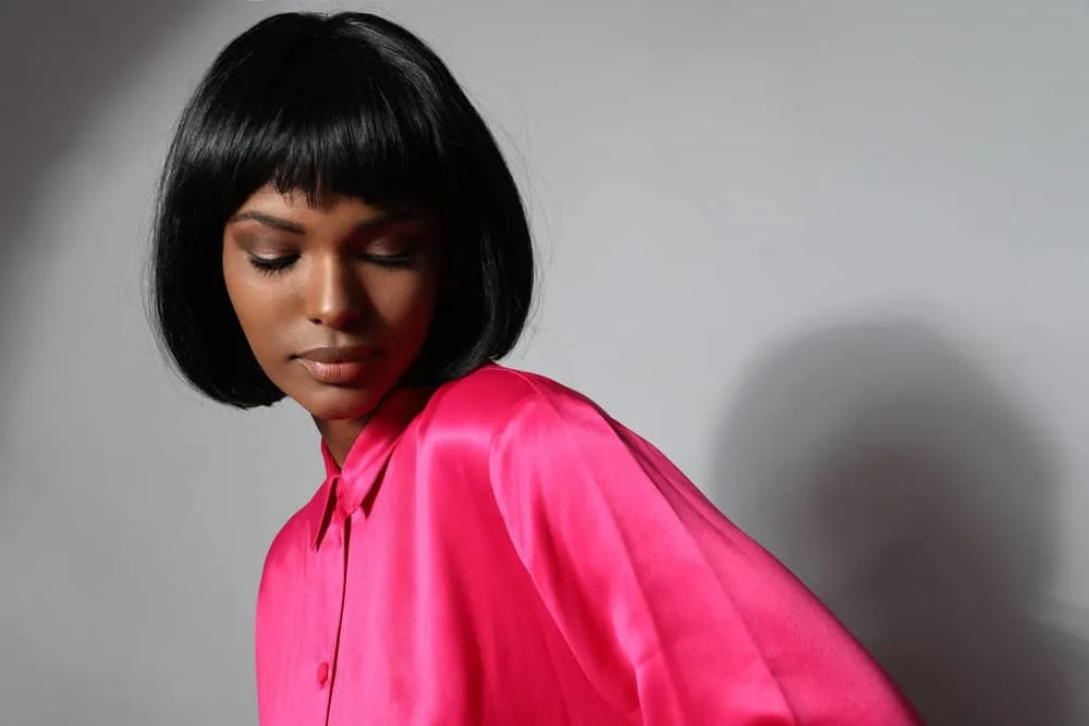 How to Cut a Bob: Cutting a DIY Bob Hairstyle on Yourself 3 Her straight hair is expertly styled into a sleek and polished bob, accentuating her features and showcasing her style with blunt cutting techniques.
