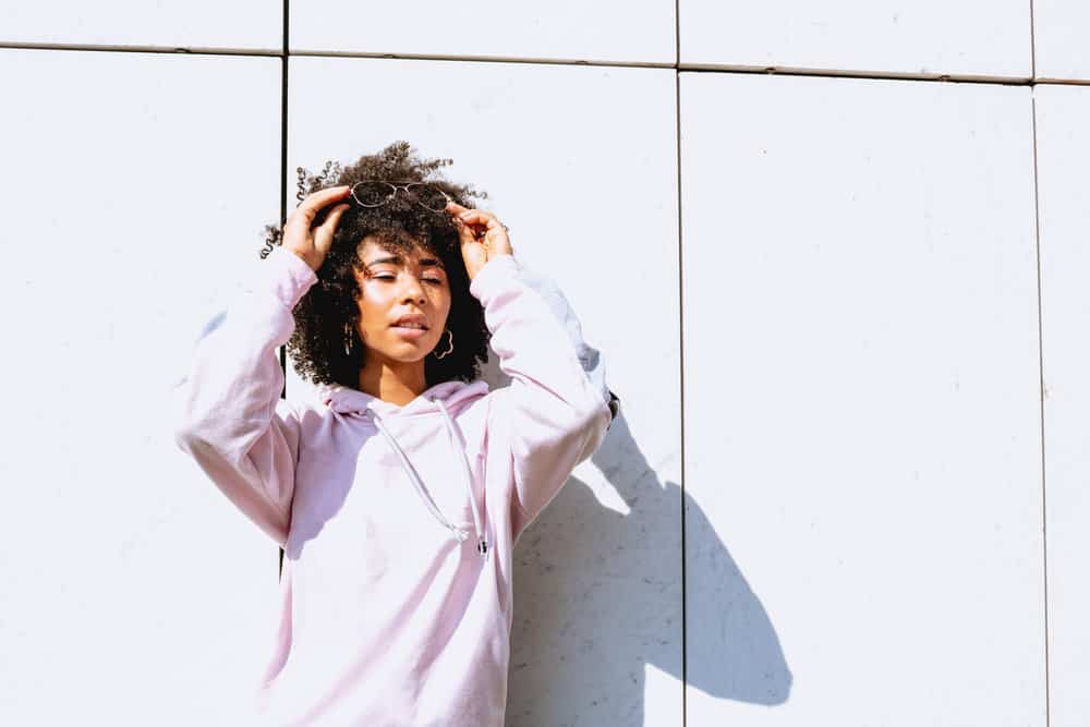 With a half braided hairstyle, this black girl combines the beauty of her natural curls with the creativity of braided accents.