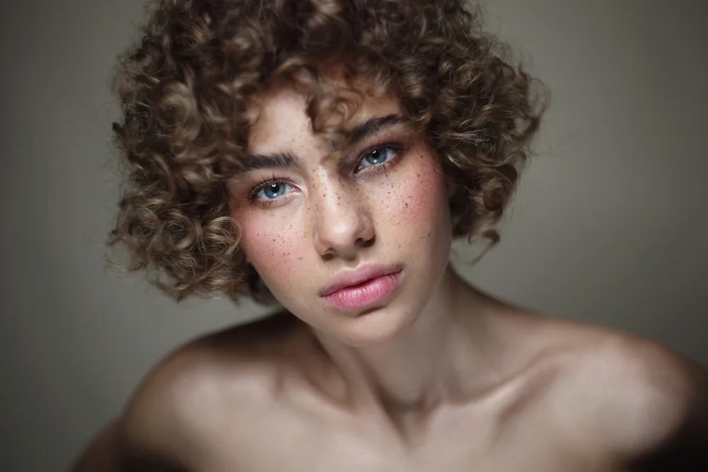 Curly Hair with Bangs: Curly Hairstyles with Fringe or Bangs 5 Her long curly texture cascades down, with thick hair strands and curly locks that exude confidence and beauty, highlighting her freshly washed curly layers.