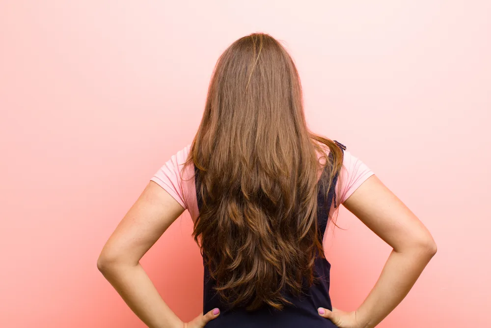 How to Grow and Style Waist Length Hair: Step-By-Step Guide 2 With her waist-length curly hair enhanced by straight extensions, this beautiful white girl showcases the versatility of different hair types.