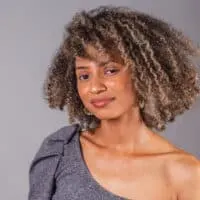 A cute black girl with oily hair used an organic shampoo and conditioner treatment before styling her natural hair strands with a natural bristle brush.