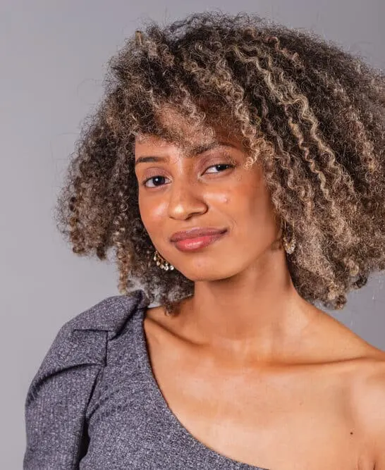 A cute black girl with oily hair used an organic shampoo and conditioner treatment before styling her natural hair strands with a natural bristle brush.