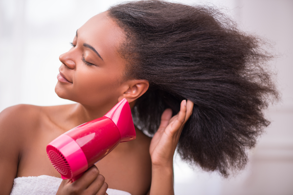 Her waist-length hair, dripping wet with detangling spray, demands her gentle touch to prevent matted hair in the future.