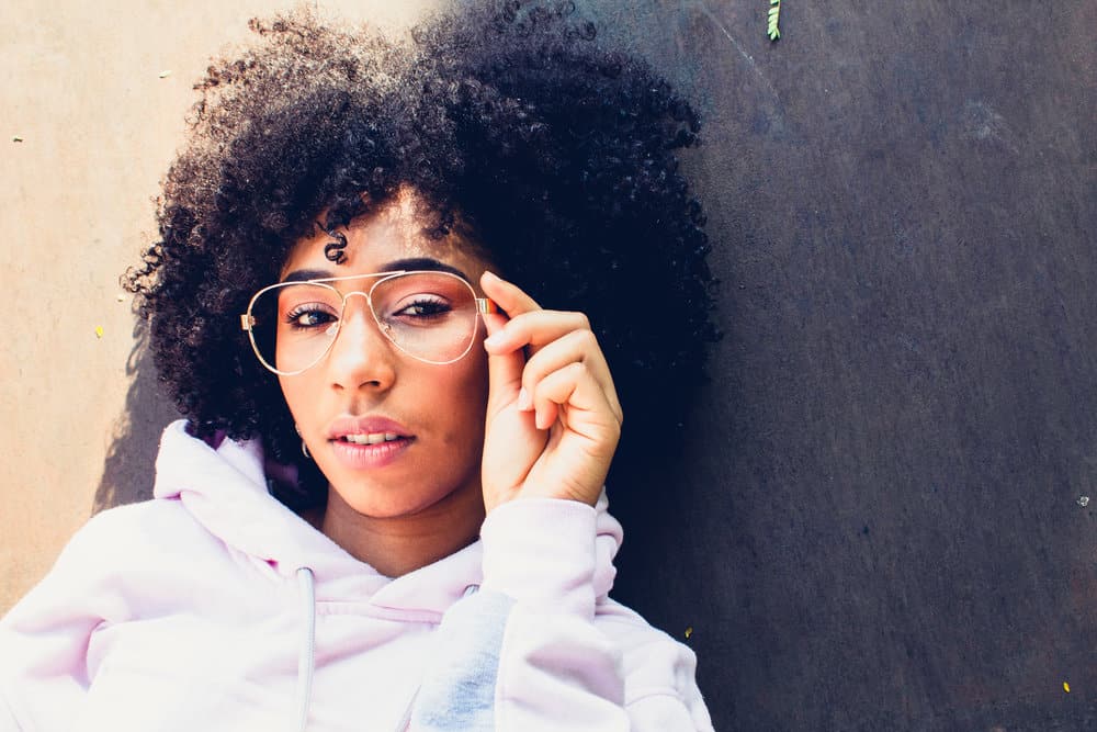 Embracing her natural beauty, this black girl flaunts her curly hair in a stunning style that highlights the beauty of her tight curls.