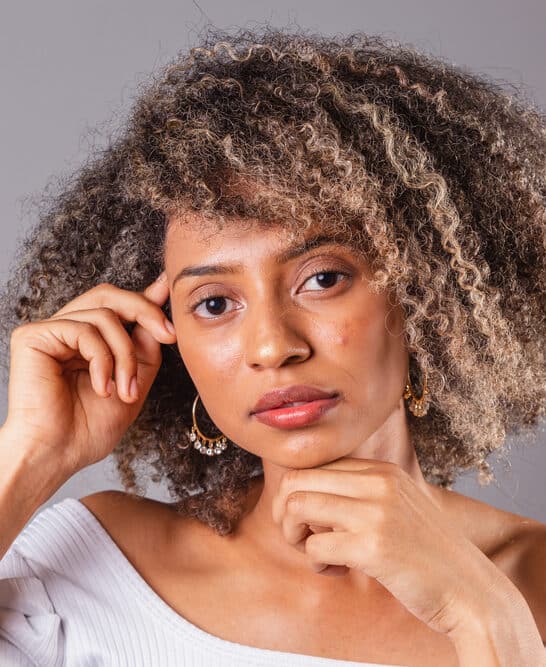 A black girl with thick hair was cleaned with a soap nut liquid natural shampoo and styled with essential oils, like a lavender essential oil.