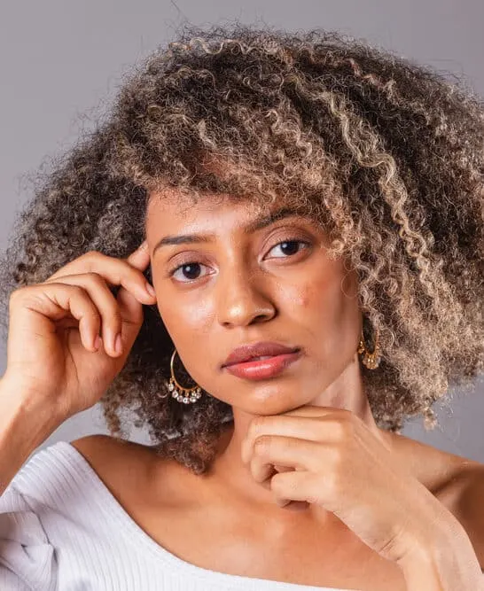 A black girl with thick hair was cleaned with a soap nut liquid natural shampoo and styled with essential oils, like a lavender essential oil.