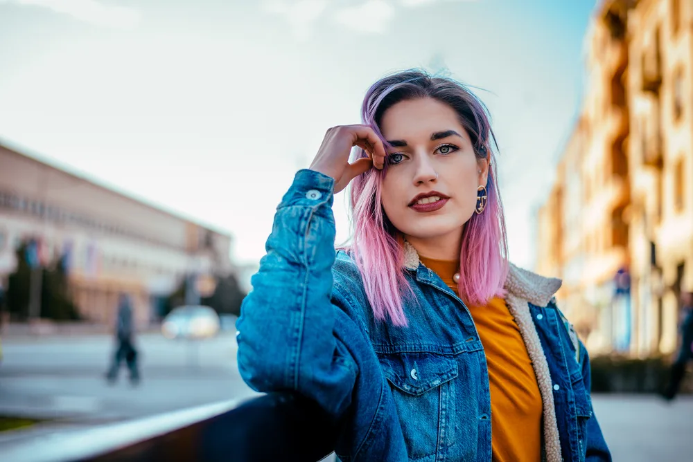 What Color Cancels out Purple? Does Yellow Cancel out Purple? 1 A beautiful white girl with naturally brown hair wearing dark purple hair dye with pinkish red tones that covers her natural hair color.