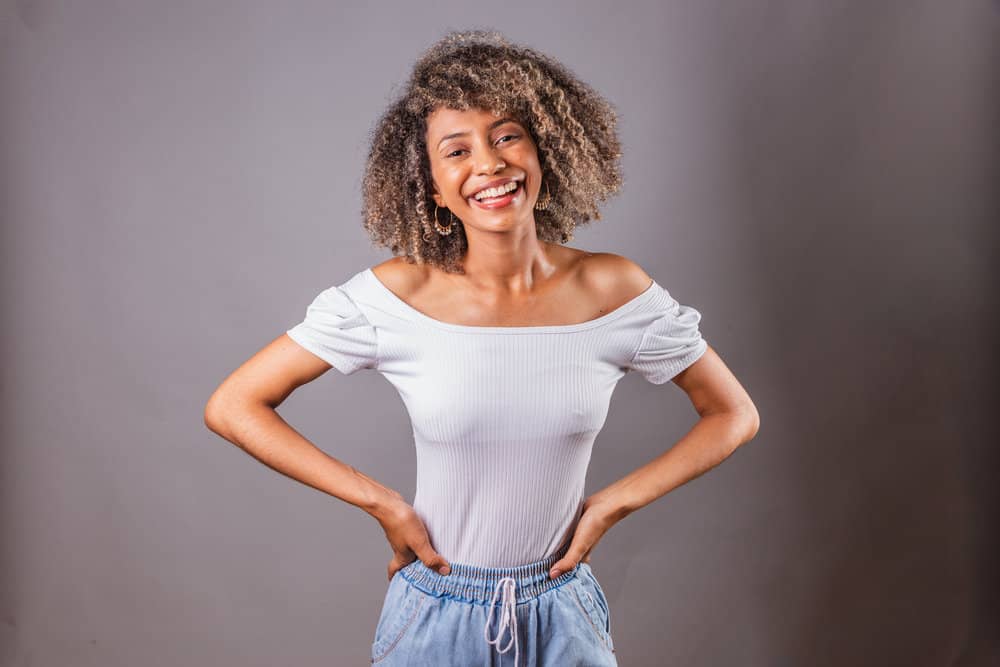 The beautiful black girl treats her thick hair with a natural soap nut liquid shampoo, free from harsh chemicals.