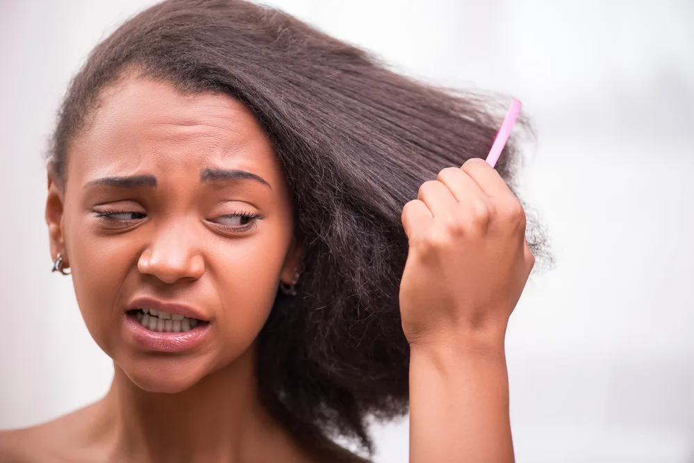She uses a fine-toothed comb to carefully work through her hair, starting from the ends and working her way up to prevent breakage.