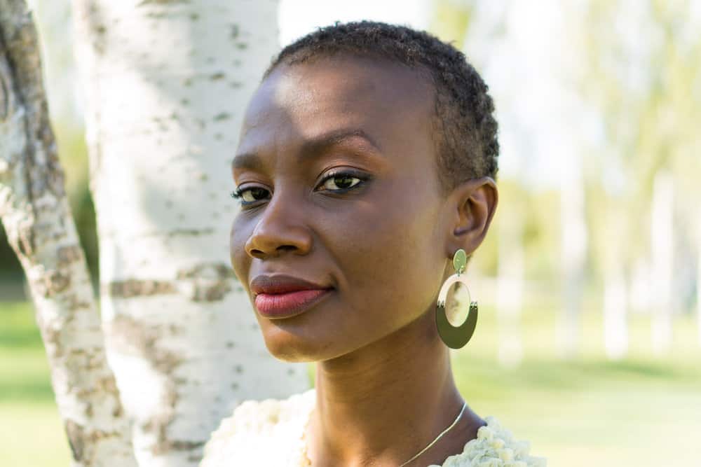 An African American woman with thin hair wearing one of the most popular short haircuts for women that highlights her natural curls.