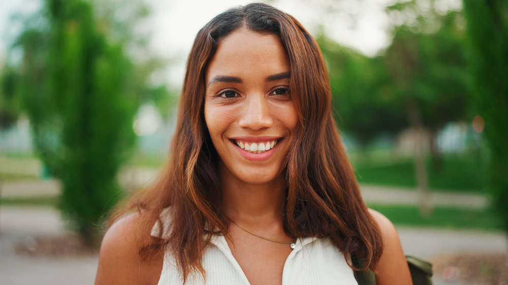 A beautiful girl with orange hair with cool tones that include hints of her dark brown natural hair color. The color matches perfectly with her brassy yellow tones.