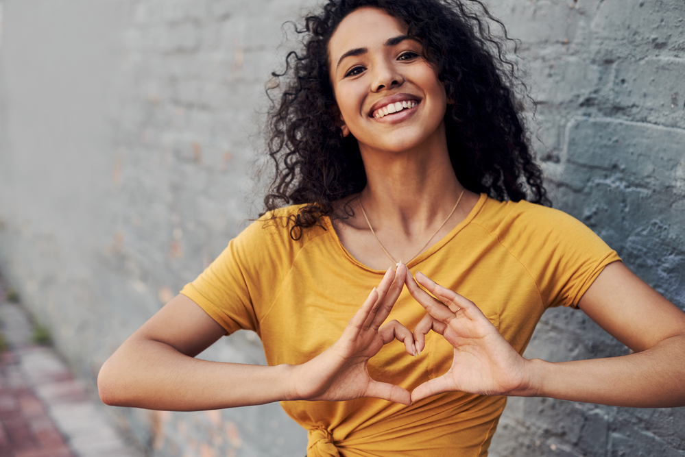 With her damp hair, this attractive young woman begins her styling routine by applying a curling gel to enhance and define her natural curl pattern.