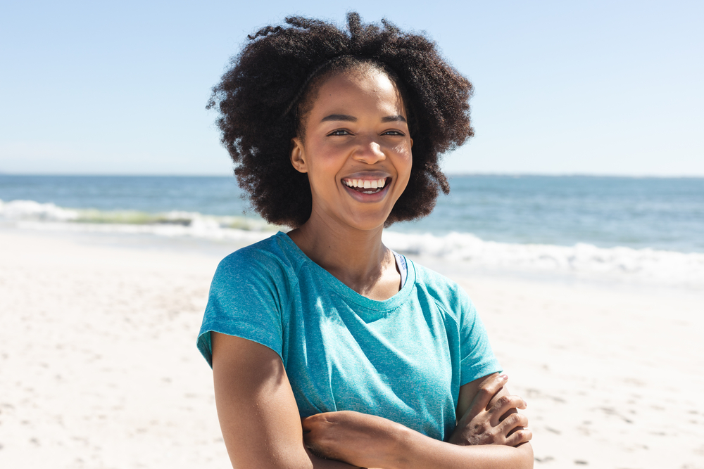 After a clarifying session, this beautiful black female nourishes her dark brown color-treated hair follicles with a blend of natural oils.