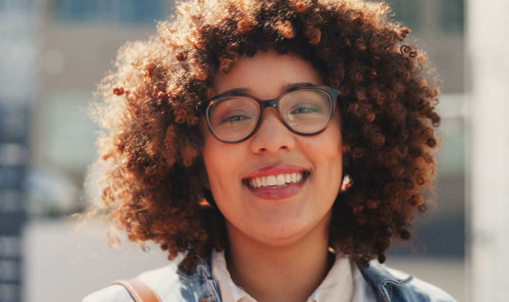 A cute African American female with dry hair styled with essential oils, like Jamaican castor oil and sunflower oil.